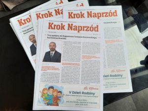 Plakat z tekstem "Krok Naprzód" oraz ilustracją przedstawiającą rodzinę. Na wydruku widnieje zdjęcie osoby w marynarce i tekst dotyczący Fundacji Pojednanie.