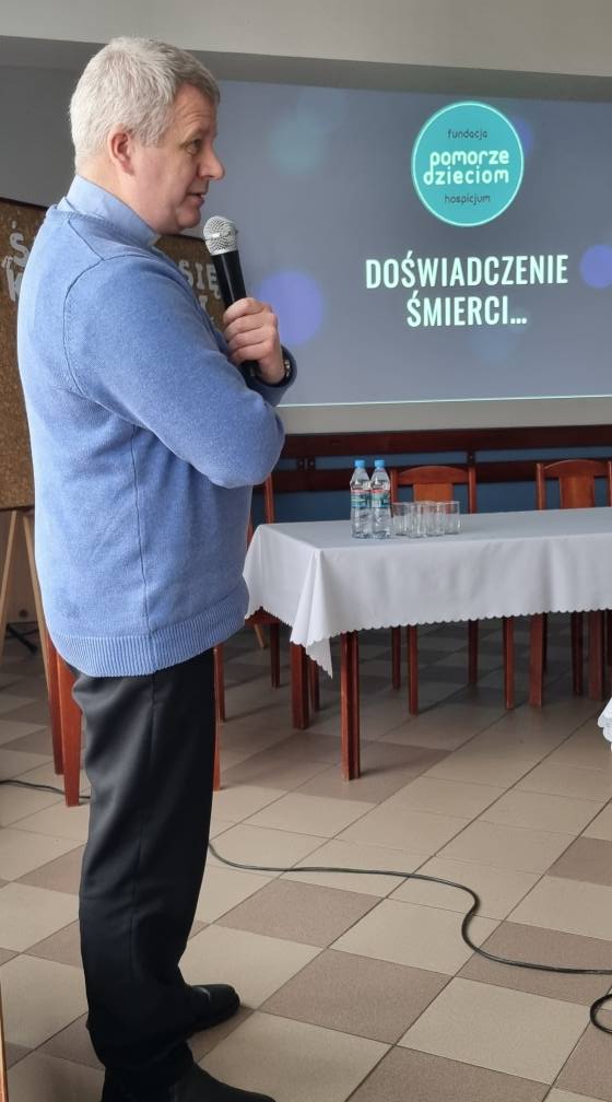 Prelegent z mikrofonem prowadzi prezentację „Doświadczenie śmierci” podczas spotkania „Żałoba i strata” w Hodyszewie.