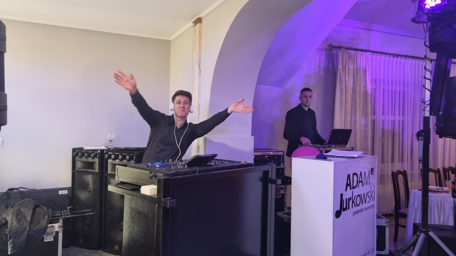 DJ przy konsolecie z uniesionymi rękami podczas Balu Charytatywnego Fundacji Pojednanie.