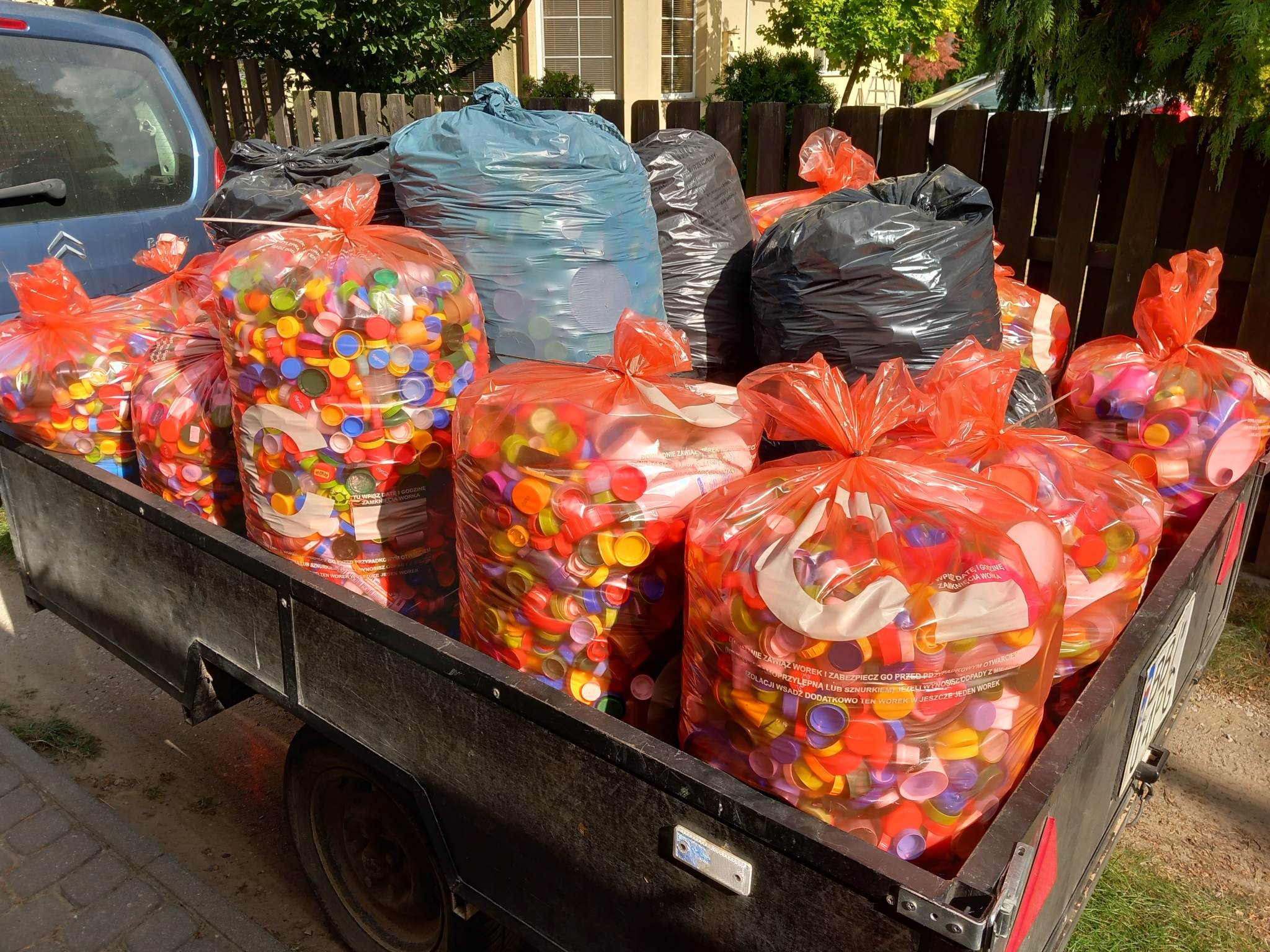 Wózek towarowy wypełniony workami z plastikowymi nakrętkami. Zbiórka nakrętek prowadzi Fundacja Pojednanie. Nakrętki można dostarczać do trzech punktów.